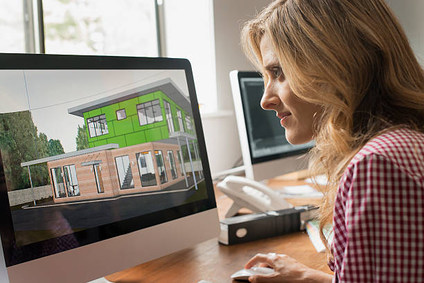 Femme qui regarde des plans de constructions sur un ordinateur