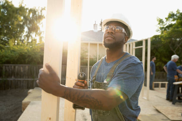 Ouvrier en train de transporter des planches de bois pour construire une maison passive